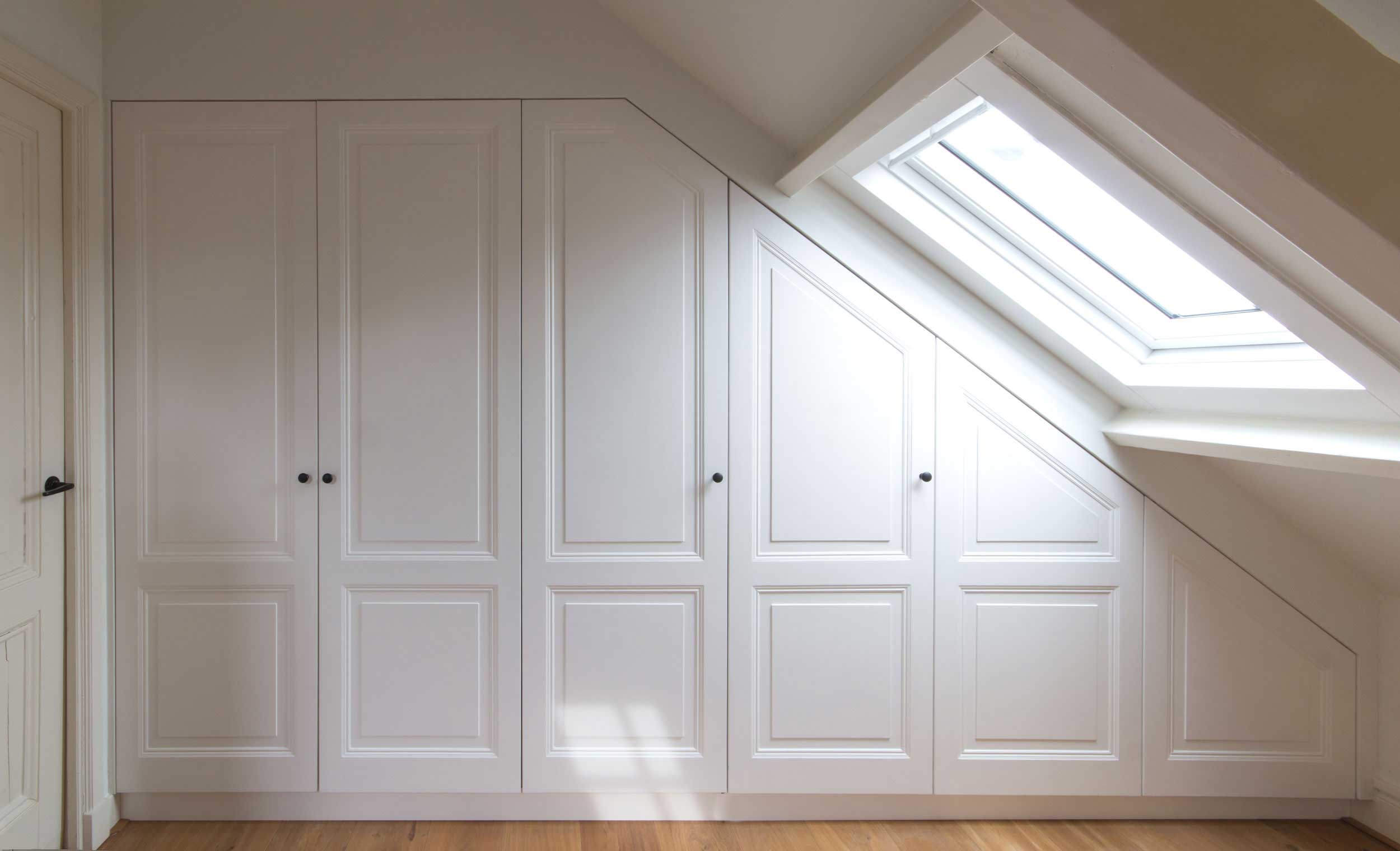 Kledingkasten schuin op maat gemaakt met traditoneel lijstwerk een kroonlijst op zolder in Hilversum