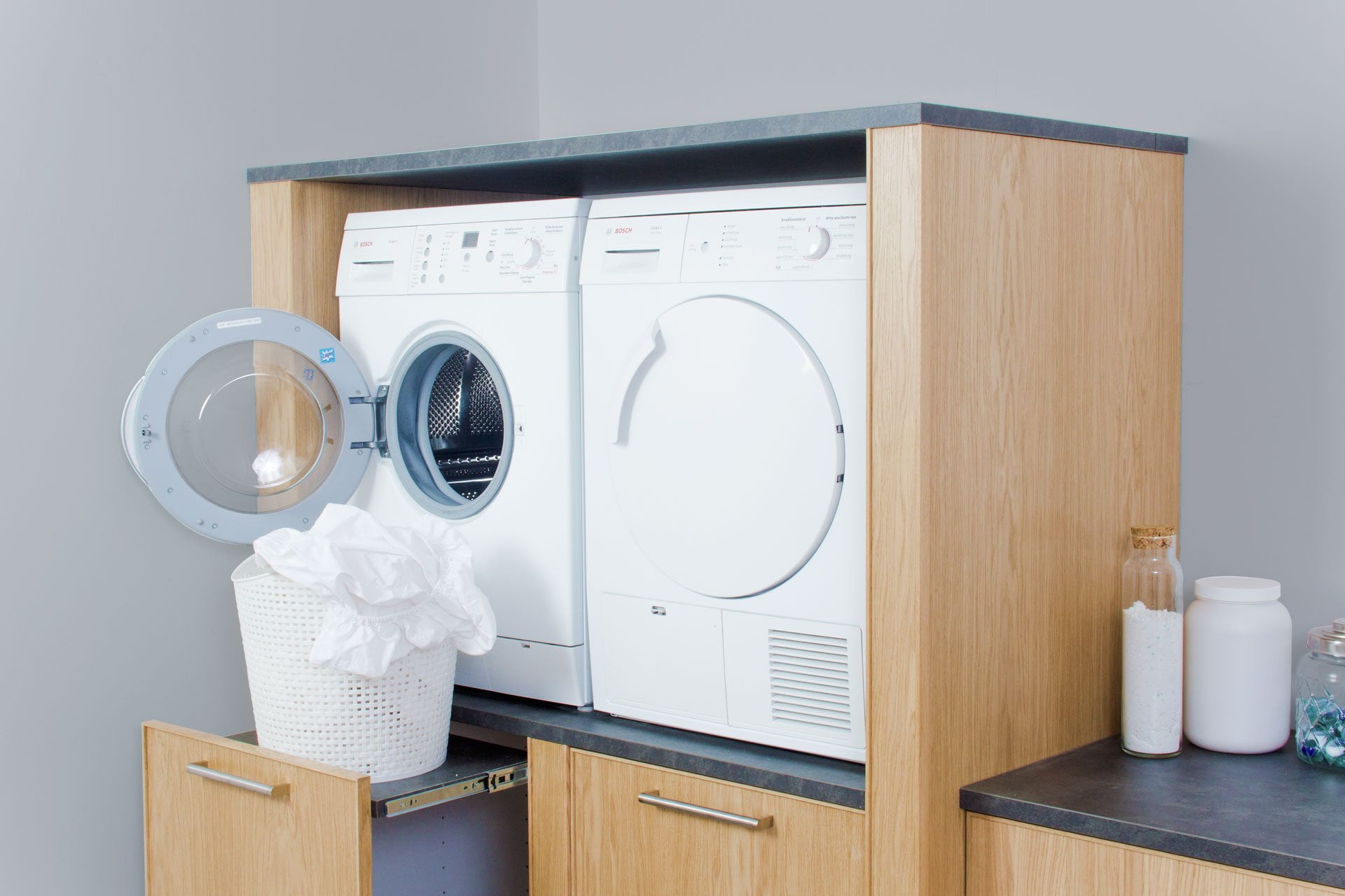 Wasmachine en droger in maatwerk meubel op comfortabele gebruikershoogte in wasruimte Laren